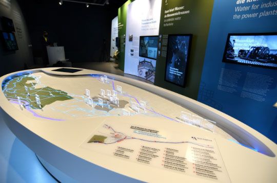 Ein Museumsexponat zeigt ein topografisches Modell mit beleuchteten Abschnitten, die Wasserwege und Kraftwerke hervorheben.