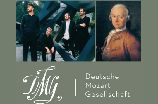Gruppe von vier Männern und ein Porträt von Leopold Mozart mit Logo der Deutschen Mozart Gesellschaft.